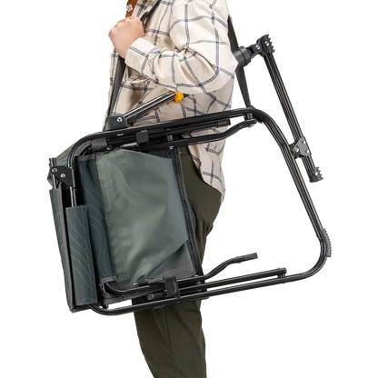 A person carrying the Hunter Topo Stowaway Rocker with a carry strap. 