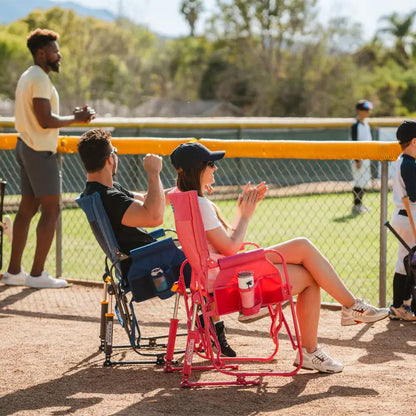 Man and woman cheering from the sidelines, seated in bright pink and navy Stowaway Rockers.